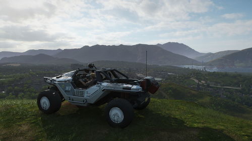 Vintage car on field against mountains