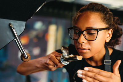 Close-up portrait of smiling young woman with eyeglasses