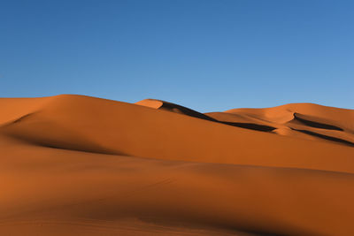 View of desert against clear blue sky