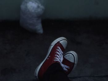 Low section of person wearing shoes in darkroom