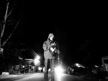 Man using phone against sky at night