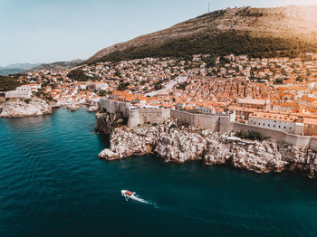 Aerial view of sea by town during sunny day