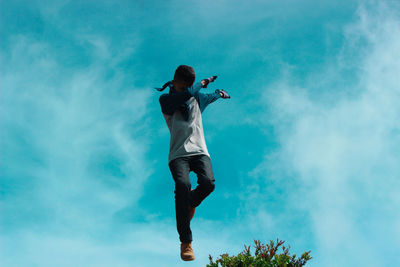 Low angle view of woman standing against sky