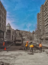 Men on construction site in city against sky