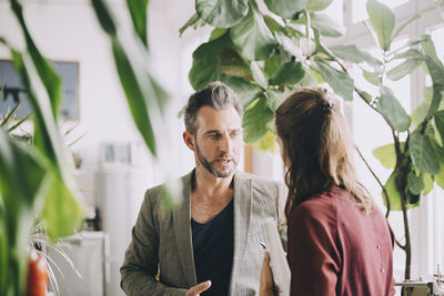 Creative businessman and businesswoman discussing in office