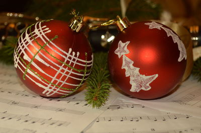 Close-up of christmas ornaments on musical notes