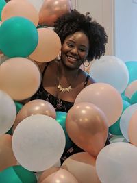 Portrait of smiling young woman with balloons