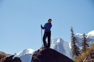 Full length of woman standing on rock against sky