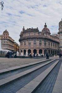 Group of people in front of historical building in city