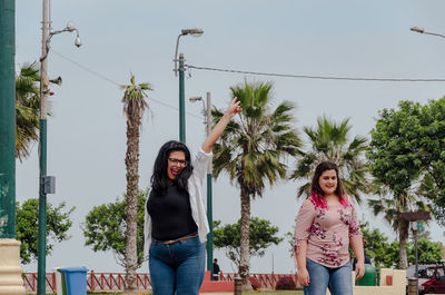 Portrait of happy friends standing in park