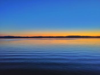 Scenic view of sea against clear sky during sunset