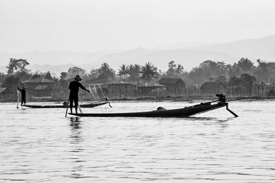 Men standing on boat against sky