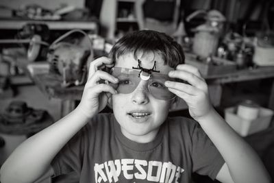 Boy looking away while wearing protective eyewear in garage