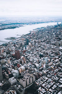 High angle view of cityscape by sea against sky