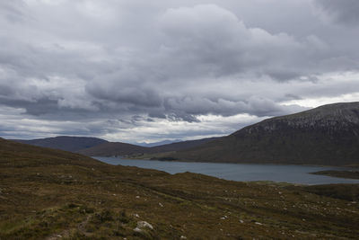 Scenic view of land and mountains against sky