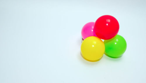 High angle view of multi colored balls on white background