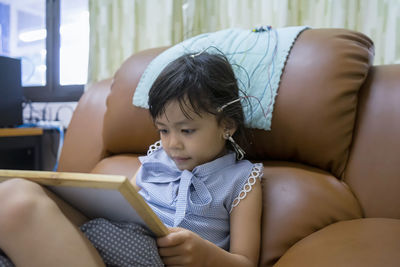 Cute girl looking at wooden box at home