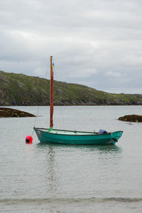 Sailboats moored on sea against sky