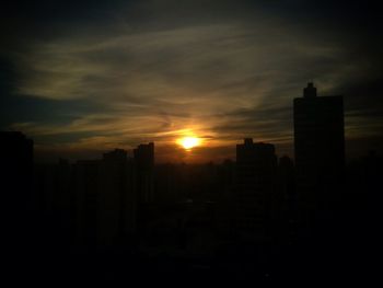 Silhouette cityscape against sky during sunset