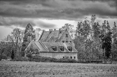 Abandoned house on field against sky