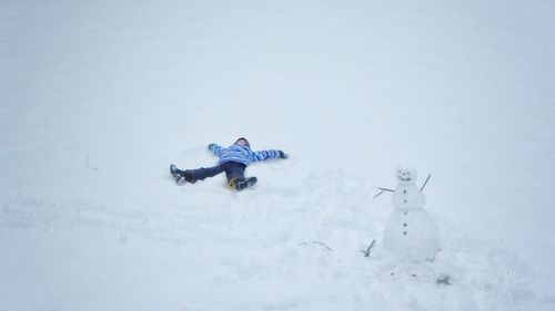 Boy lying down on snow