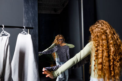 Rear view of woman standing against wall