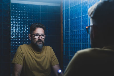 Man looking at mirror at bathroom