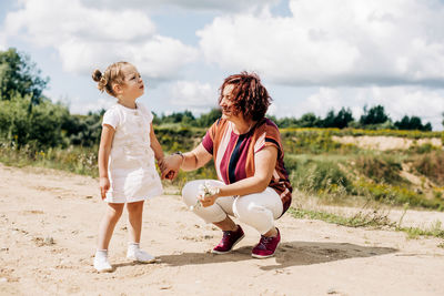 Rear view of mother and daughter on land