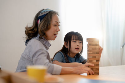 Mother and daughter playing jenga at home