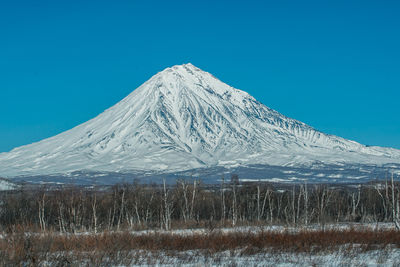 Scenic view of snowcapped mountains against clear blue sky