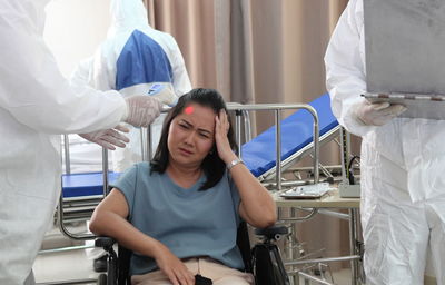 Doctor checking temperature of patient at hospital