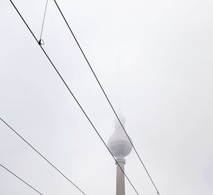 Low angle view of electricity pylon against clear sky