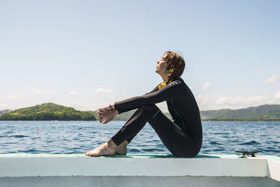 Young woman in wetsuit at del coco beach on sunny day