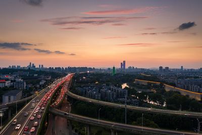 High angle view of street amidst buildings against sky during sunset