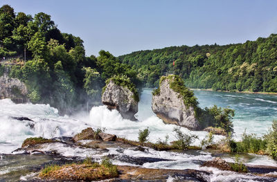 Scenic view of waterfall against sky