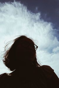 Low angle view of woman wearing sunglasses against sky