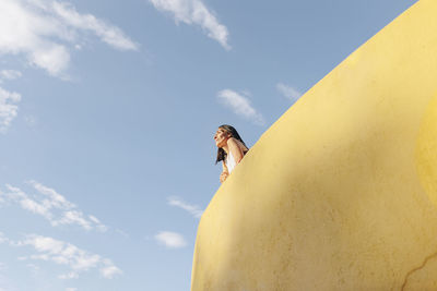 Contemplative woman leaning on wall