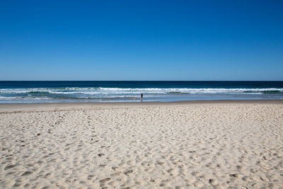 Scenic view of beach against clear blue sky