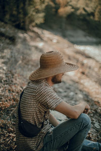 Side view of a woman sitting on field