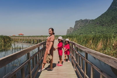 Mon and two cute little girls standing in bridge