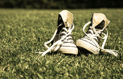 Close-up of canvas shoes on grassy field