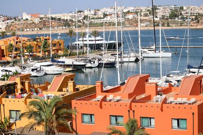 Sailboats moored at harbor in city