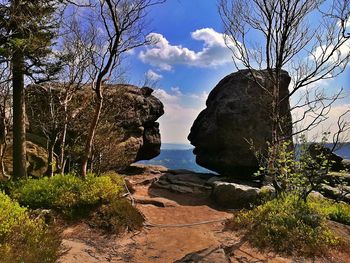 Rocks by trees against sky