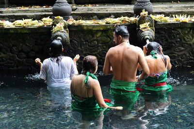 People taking bath in fountain at temple