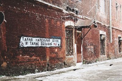 Information sign on wall in city during winter