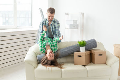 Young woman sitting on sofa at home