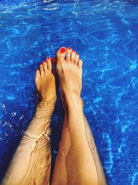 Low section of woman legs in swimming pool