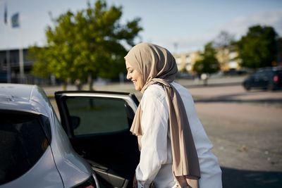 Smiling woman entering car