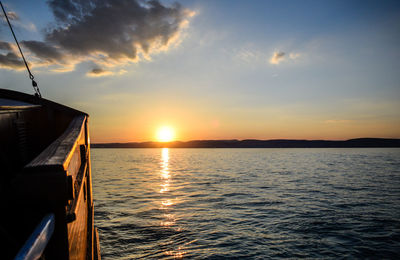 Boat sailing on sea against sky during sunset