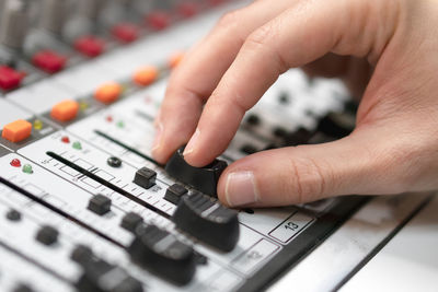 Close-up of hand adjusting button of control panel